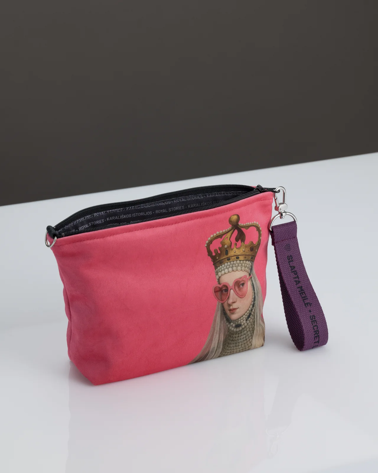 Open pink cosmetic bag “Rebel Queen” on a white table from the “Rebel Queen's Gifts” set