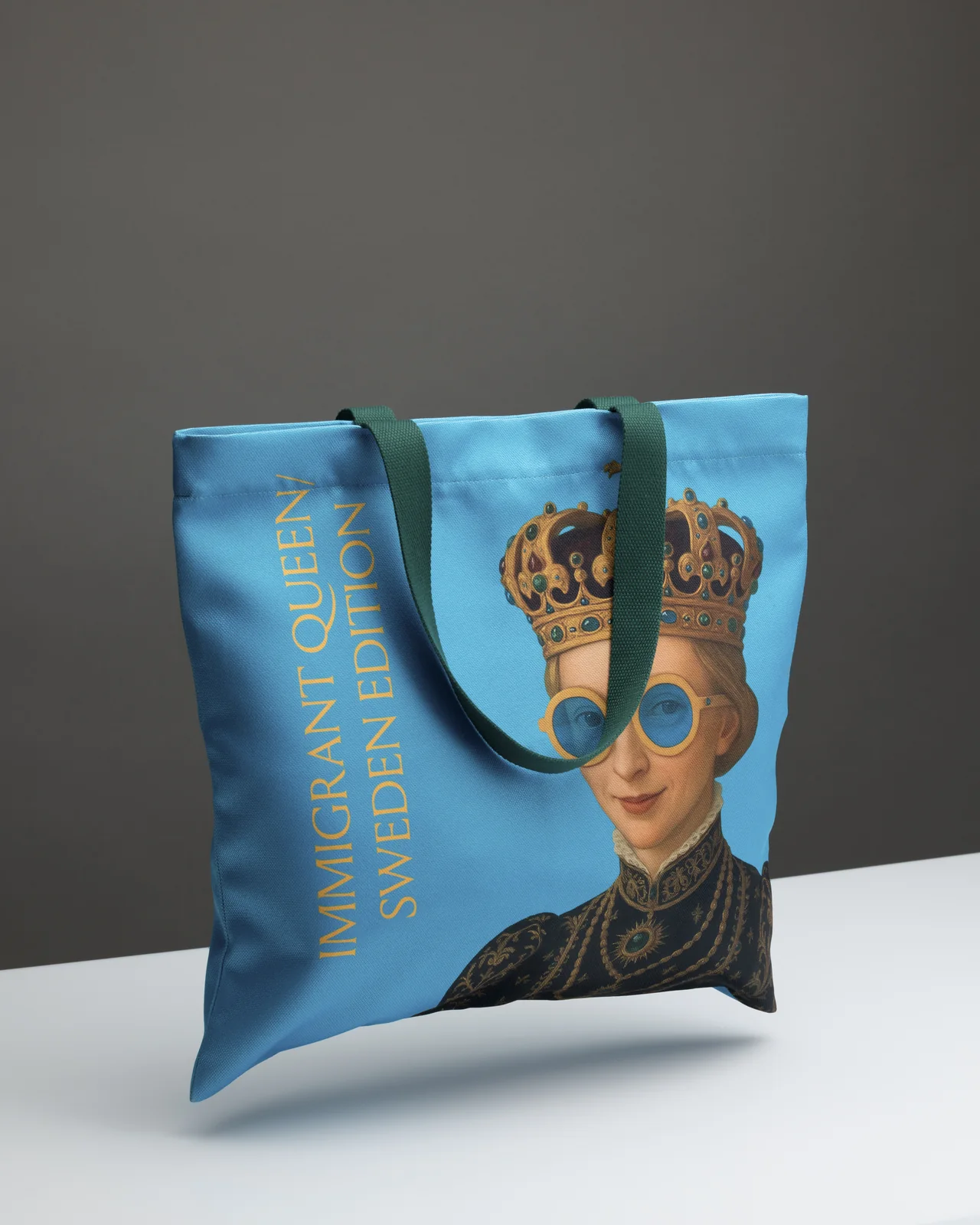 Blue “Queen Catherine” shopping bag with handles down and the queen's glasses, at an angle