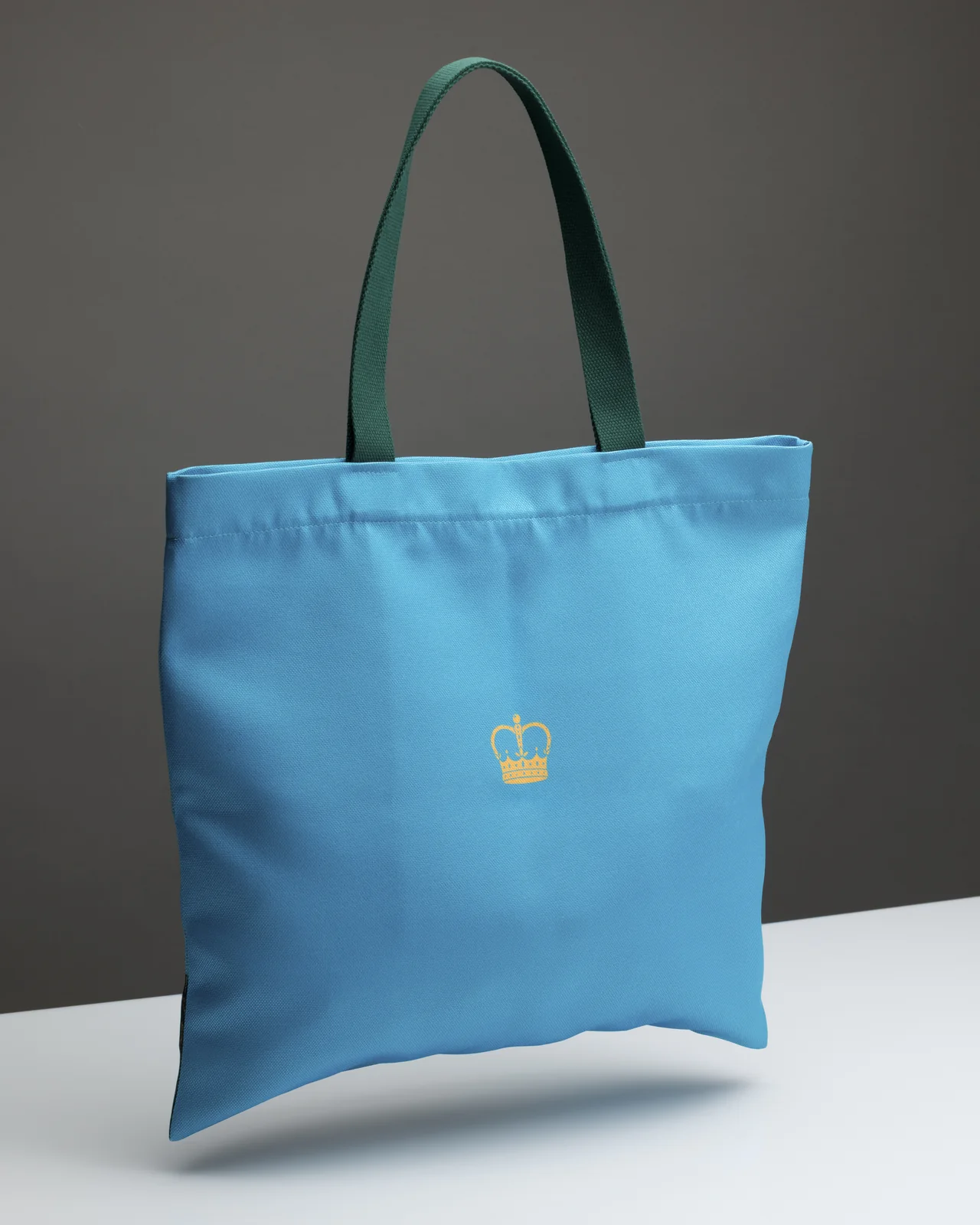 Back of the blue “Queen Catherine” shopping bag with dark green handles and a crown mark