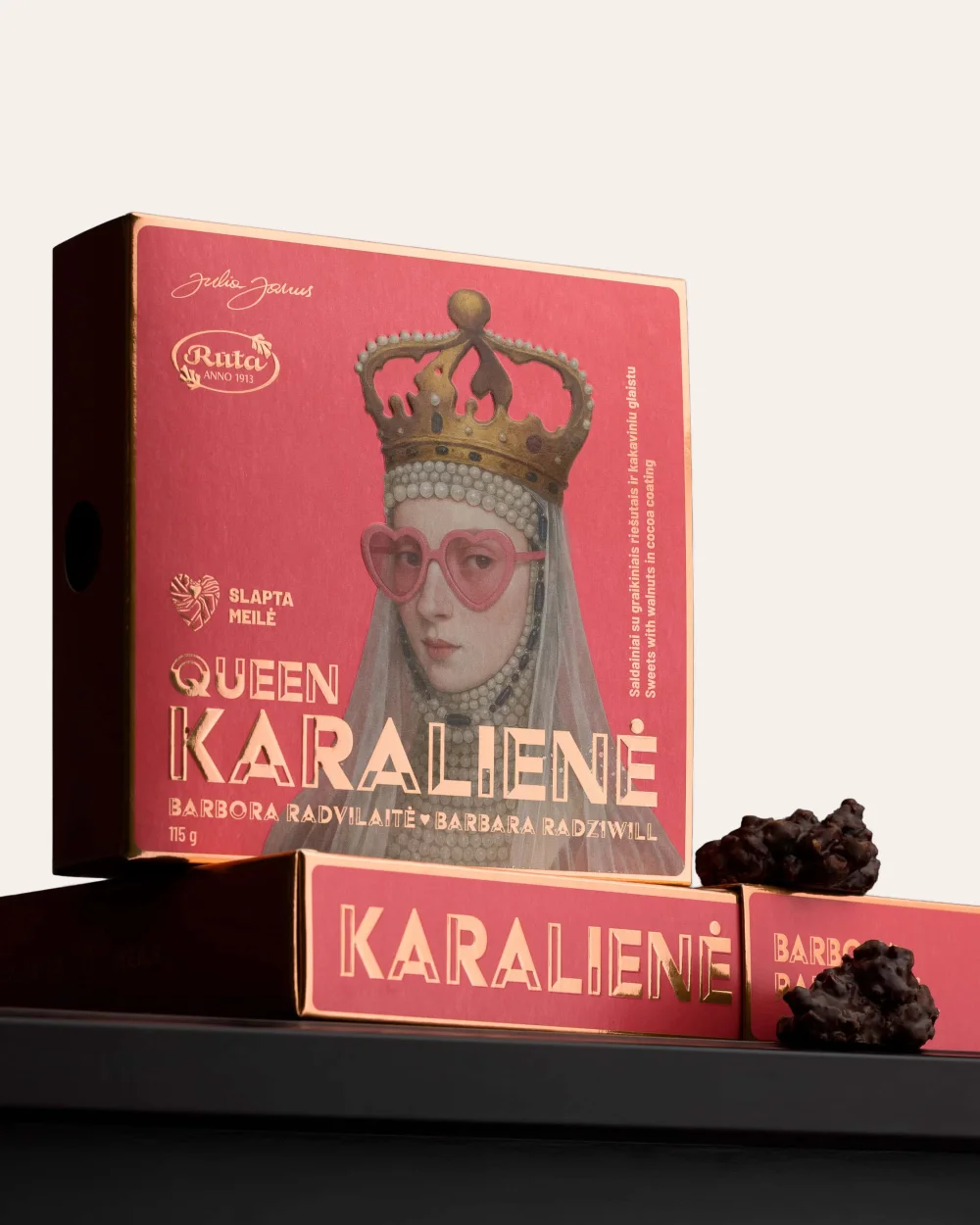 Saldainių „Karalienė Barbora Radvilaitė“ dėžutė su portretu ir saldainiais ant juodos lentynos