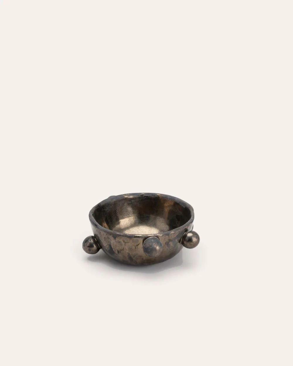 Small dark gold “The Queen's Pearl Bowl” with balls on a light background