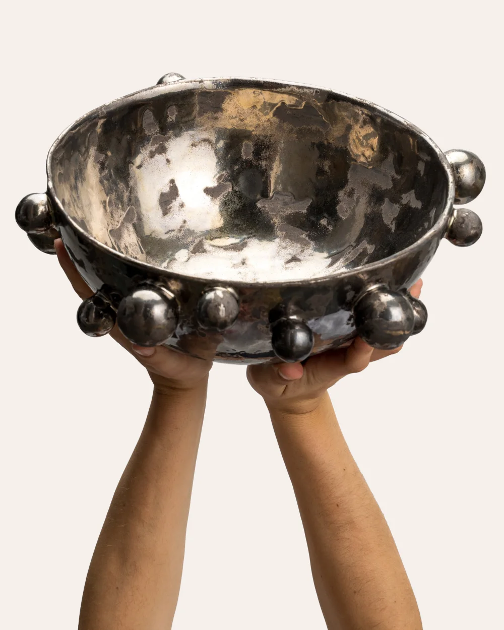 Large dark gold “The Queen's Pearl Bowl” raised in hands, glossy inside visible
