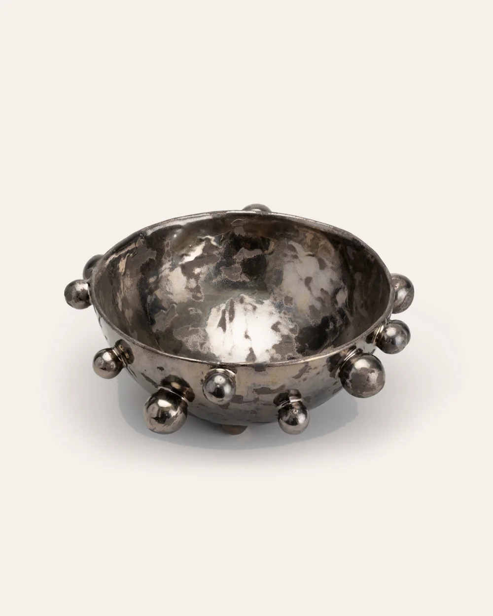 Large dark gold “The Queen's Pearl Bowl” with many little balls on a light background