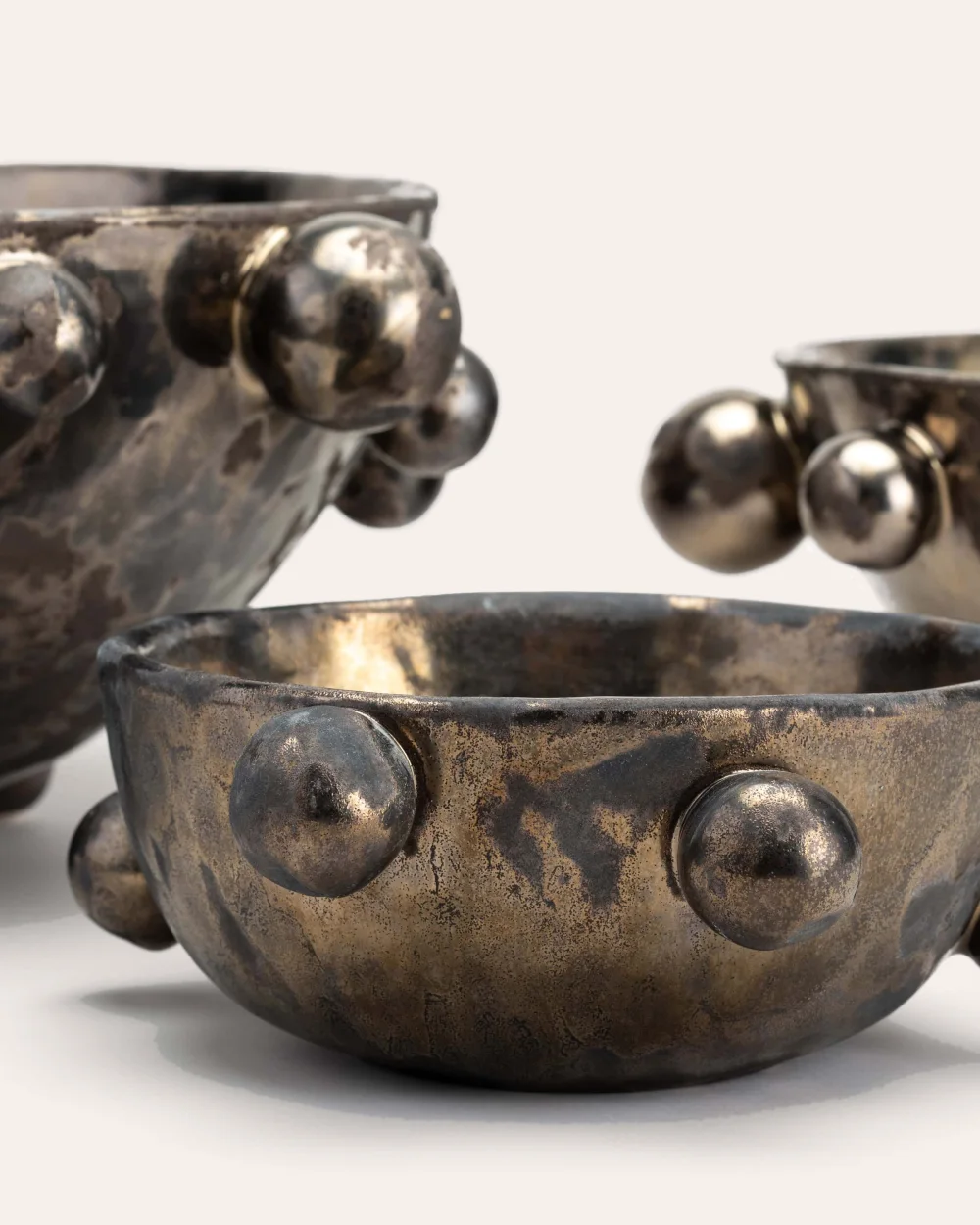 Close-up of the glaze and beads of dark gold “The Queen's Pearl Bowl” bowls