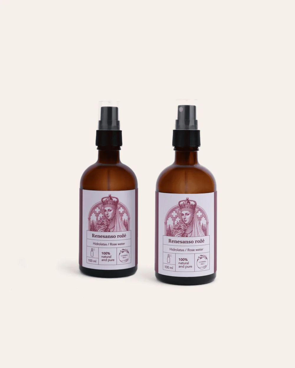 Two brown bottles of “Renaissance Rose” rose hydrosol with sprays on a light background