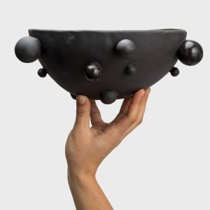 Medium matte black “The Queen's Pearl Bowl” held in one hand