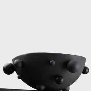 Side of a medium matte black “The Queen's Pearl Bowl” on the edge of a shelf