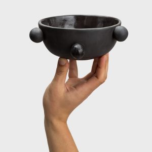 Small matte black “The Queen's Pearl Bowl” on the palm of one hand