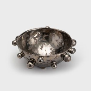 Large dark gold “The Queen's Pearl Bowl” with many little balls on a light background