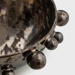 Close-up of the rim and beads of a dark gold “The Queen's Pearl Bowl”