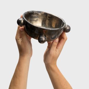 Small dark gold “The Queen's Pearl Bowl” in two hands, front view