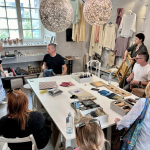 Tour participants at a table in a workshop with woven lamps – “Royal Vilnius Love Stories”