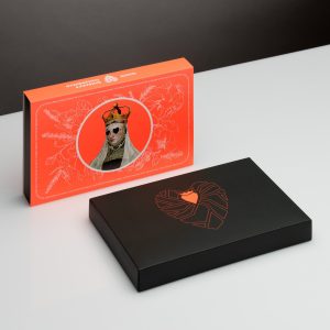 Orange box of “Queen Barbara's” gingerbread and a black box with a heart drawing on a table