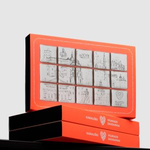 Orange boxes of “Royal Vilnius” gingerbread with Vilnius drawings on a black surface