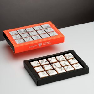 Orange and black boxes with fifteen square “Royal Vilnius” gingerbread biscuits on a table