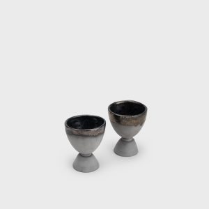 Two black ceramic “Kings' Goblets” on a light background, angled top view