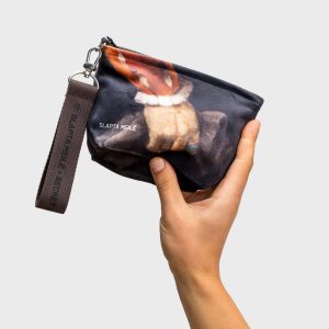 “Augustus” cosmetic bag with a dark handle and a painting detail, held in a hand, seen from below
