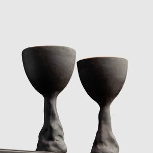 Two black Kings' Goblets on the edge of a shelf, side view