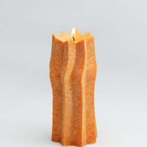 Orange ribbed candle “King Sigismund Augustus” burning on a light background