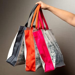 Four “Royal Vilnius” handbags with sides and handles in different colours in a hand