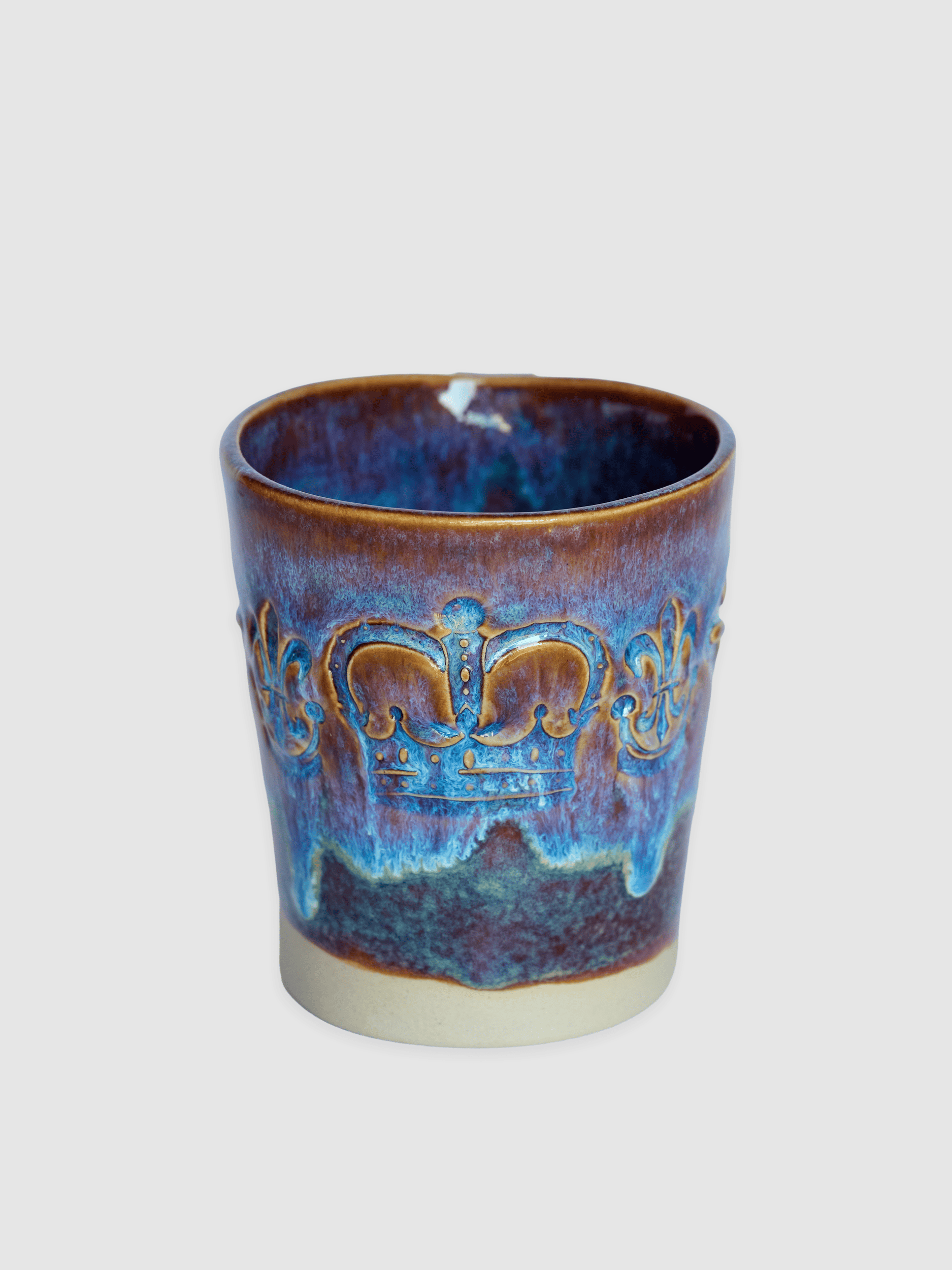 Blue-violet “Audience” mug from the front with a relief crown on a light background