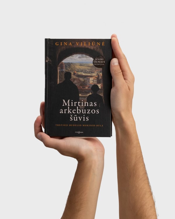 Hand holding Gina Viliūnė's book “A Fatal Arquebus Shot”, front cover visible