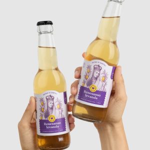 Two hands hold two bottles of “Renaissance Lavender” lemonade as if clinking them
