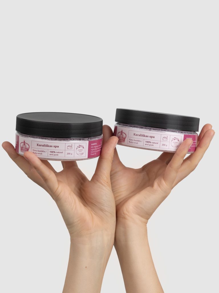 Two jars of “Royal SPA” rose body scrub with black lids in hands