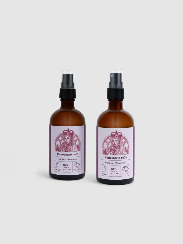 Two brown bottles of “Renaissance Rose” rose hydrosol with sprays on a light background