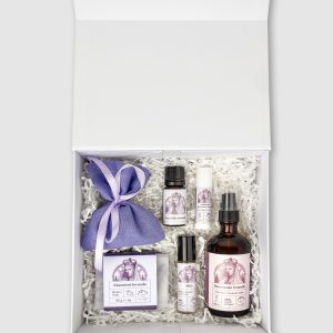 Open white box “Queen Barbara's SPA” with a lavender sachet and bottles on paper
