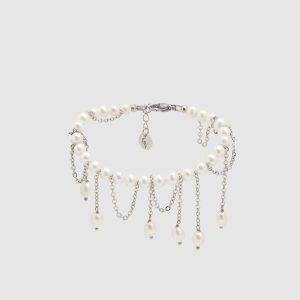Silver-coloured “The Queen's Whim” bracelet with dangling chains and pearls on a light background