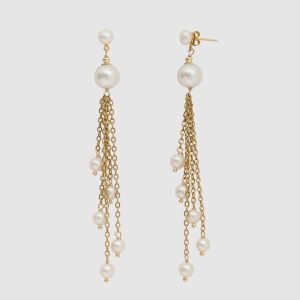 Gold earrings “The Queen's Spring” with pearls and dangling chains on a light background