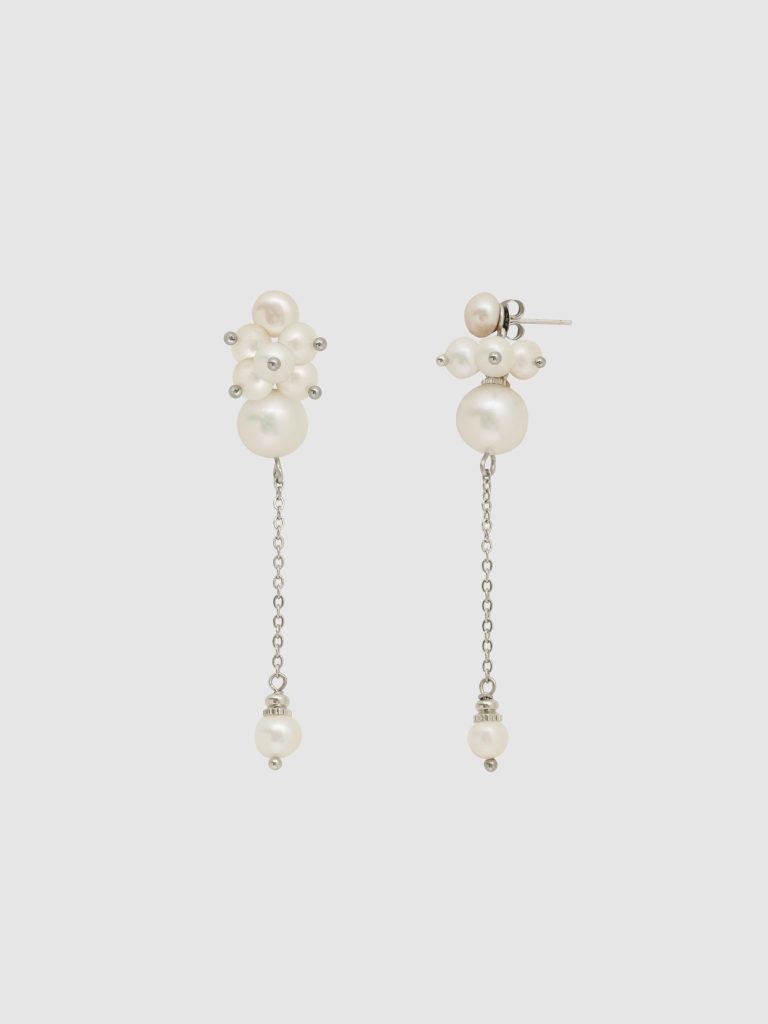 Earrings “The Queen's Garden” with a cluster of pearls and a long chain on a light background