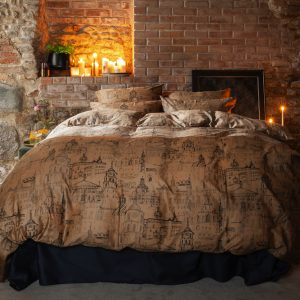 Bed with cinnamon “Royal Vilnius Love Story” satin bedding in a cosy interior with candles