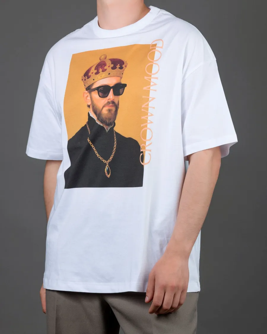 Man in a white “CROWN MOOD” T-shirt, slightly side-on view