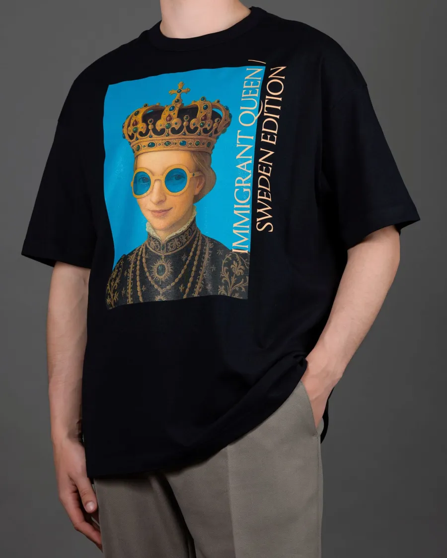 Man in a black “IMIGRANT QUEEN / SWEDEN EDITION” T-shirt, hand in pocket