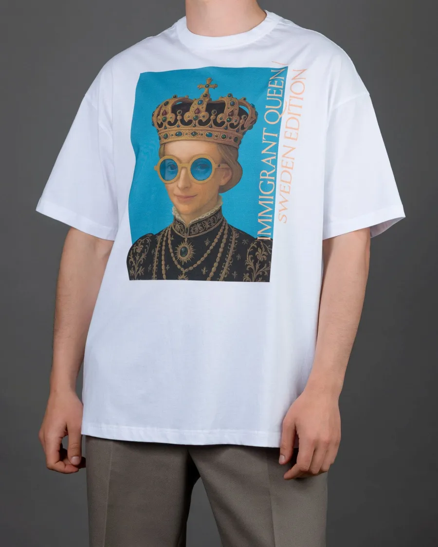 Man wearing a white “IMIGRANT QUEEN / SWEDEN EDITION” T-shirt and grey trousers