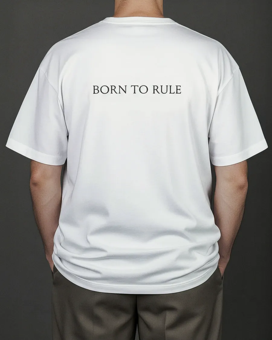 Back of the white “KARŪNA” T-shirt with the words “Born to rule” on a man