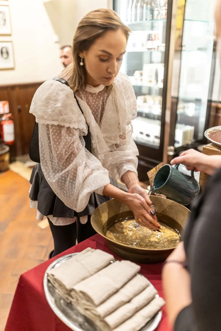 Woman stirring a dish in a large bowl at a table – Vilnius Royal Hunt Dinner
