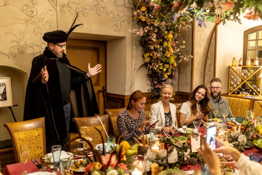 Host in a hat and cloak speaking to guests – Vilnius Royal Hunt Dinner