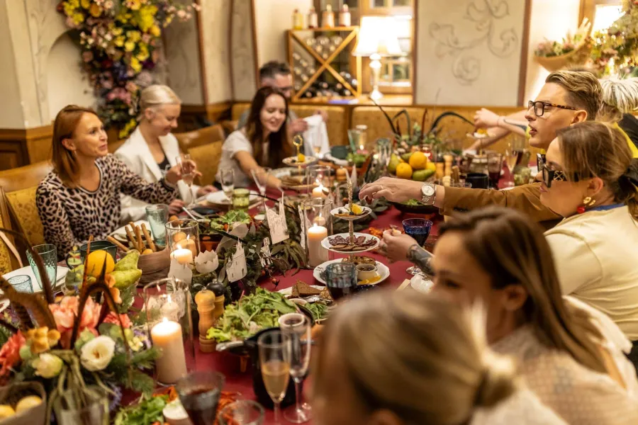 Guests at a long table with candles and dishes – Vilnius Royal Hunt Dinner
