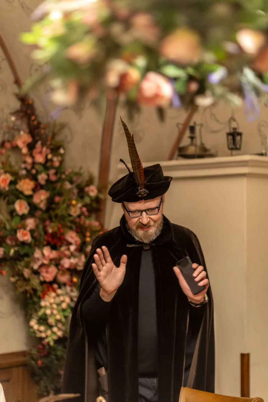 Host in a feathered hat and black cloak – Vilnius Royal Hunt Dinner