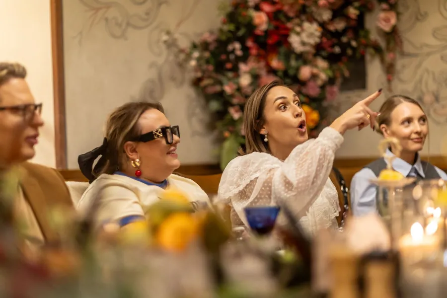 Guests at the table laughing and pointing to the side – Vilnius Royal Hunt Dinner