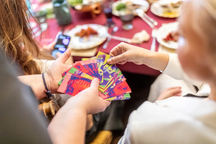 Guests holding colourful cards above the table – Vilnius Royal Hunt Dinner