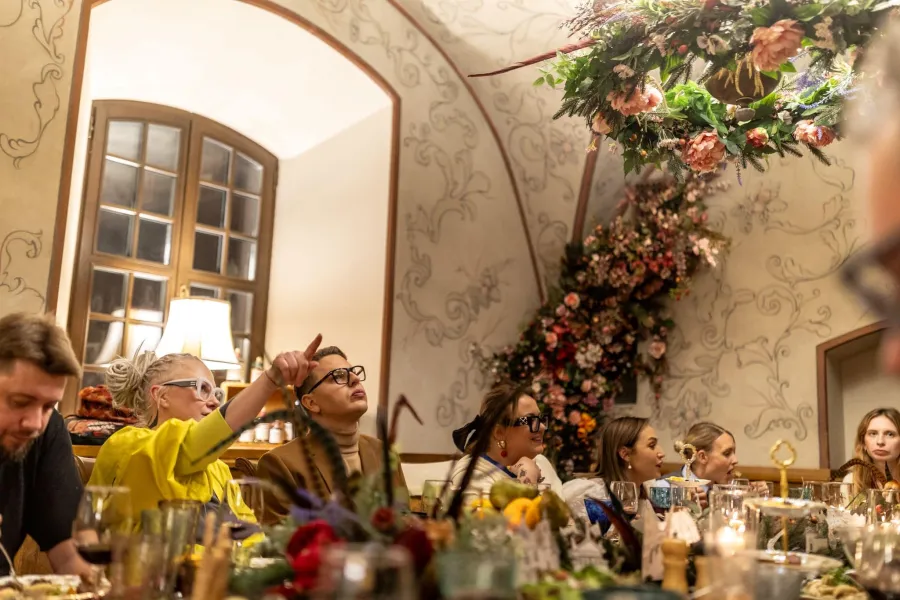 Guests at a table in a vaulted hall decorated with flowers – Vilnius Royal Hunt Dinner
