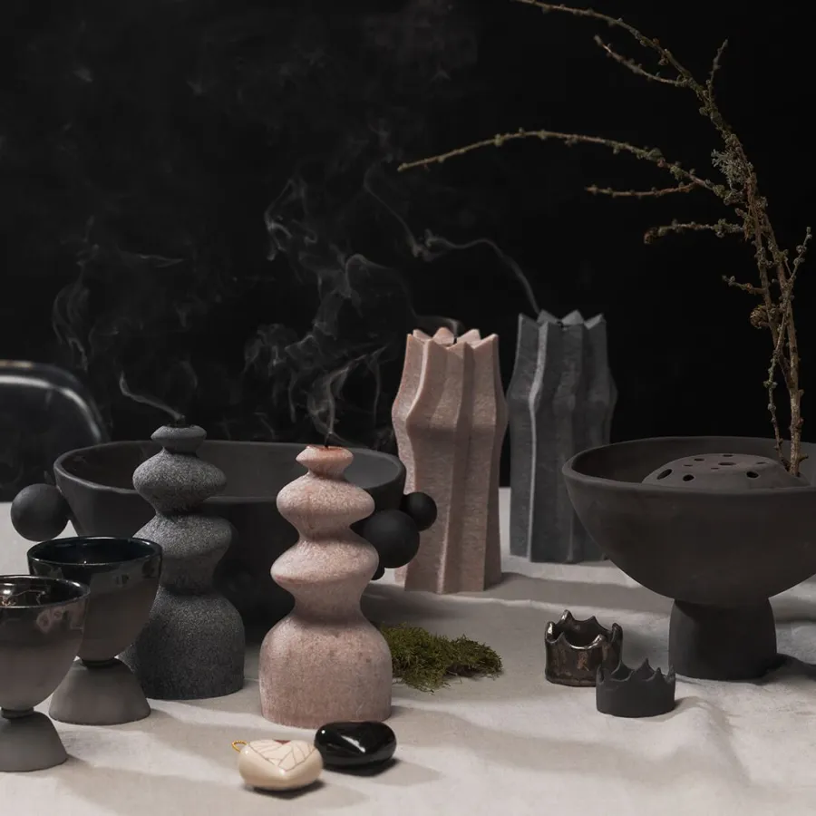 Renaissance-style bouquet vase among ceramic figurines and smoking incense