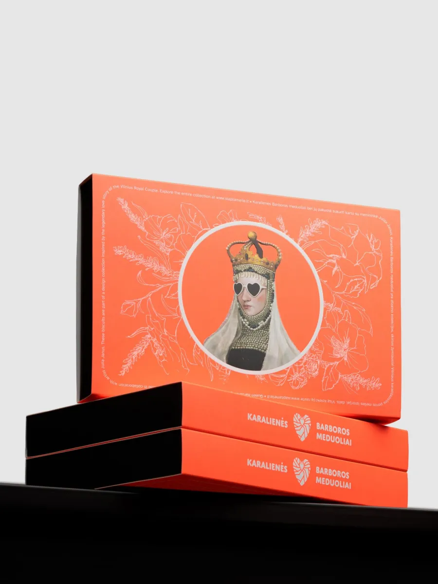 Orange boxes of “Queen Barbara's” gingerbread with the queen's portrait stacked on a black surface