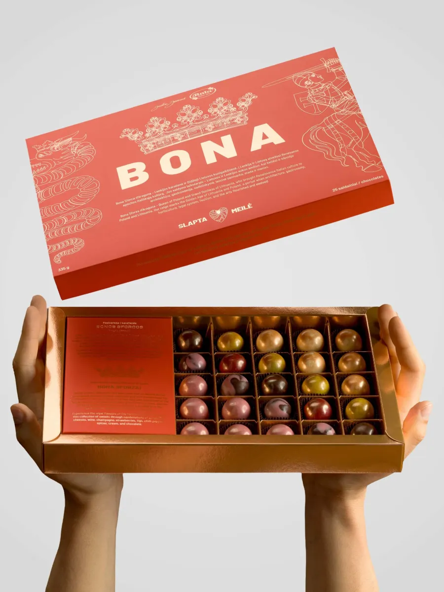 Hands holding an open “Bona” sweets set with colourful sweets, the lid above it
