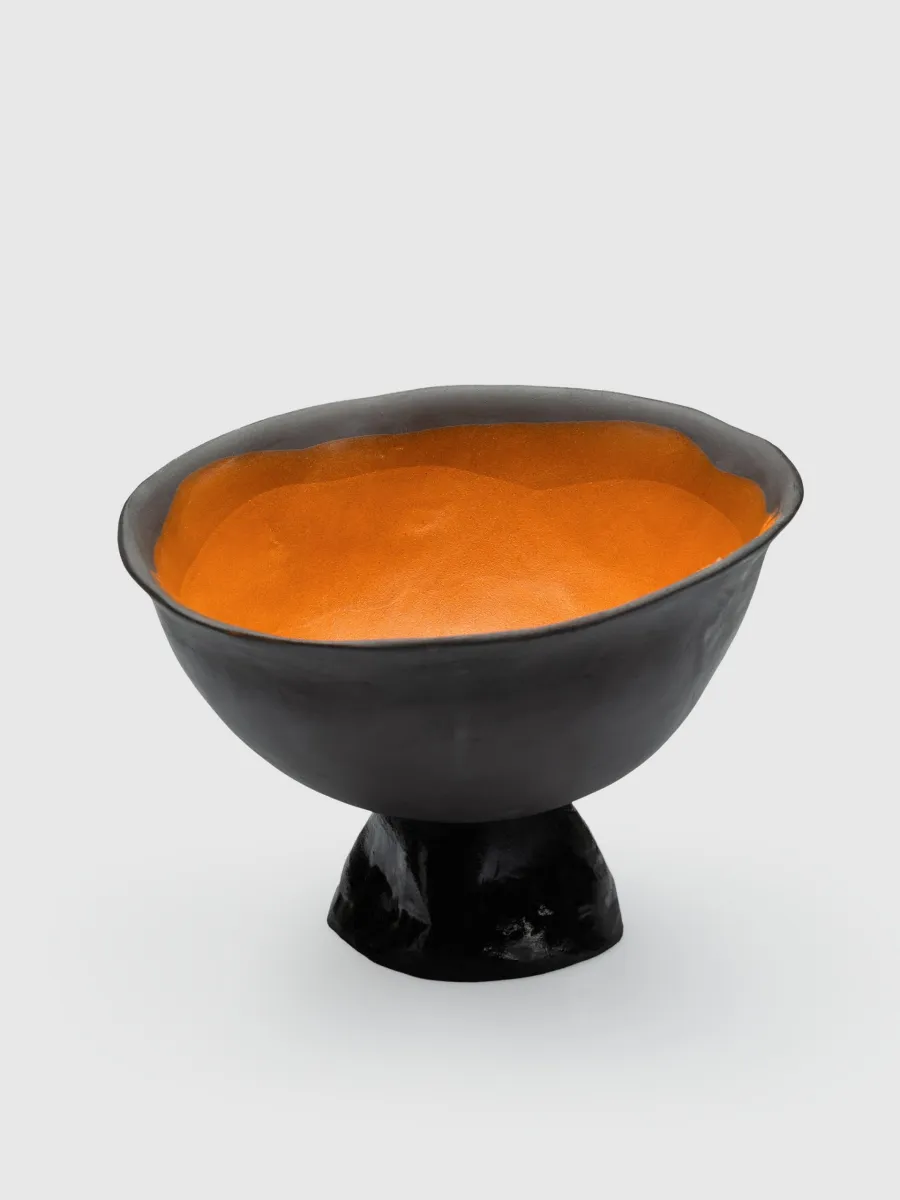 Black Kings' Footed Bowl with orange glaze inside on a light background