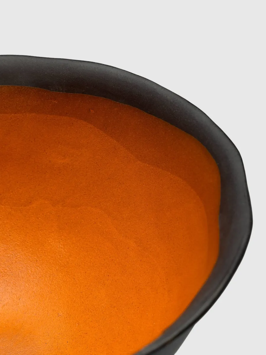 Close-up of the orange inner glaze and black rim of the Kings' Footed Bowl